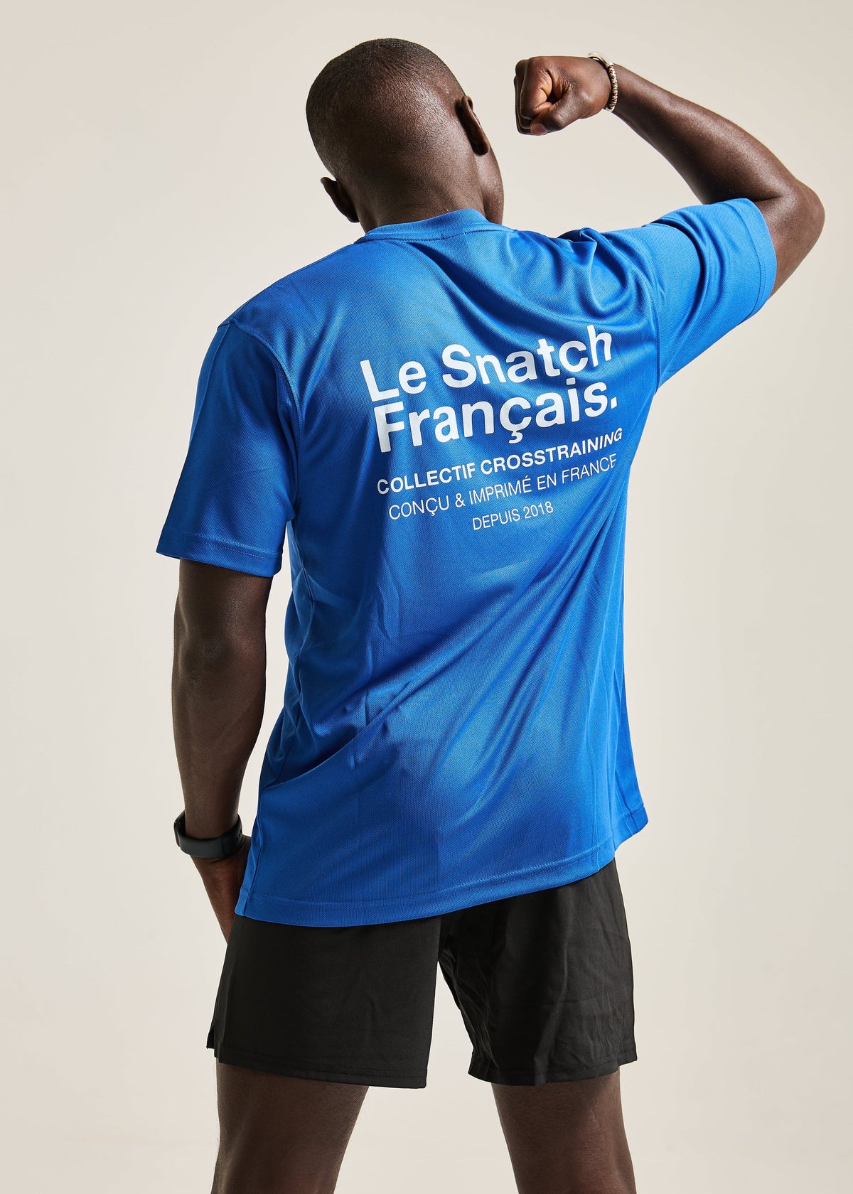 T-shirt Aerix bleu Collectif Cross-training porté de dos avec un short noir Image
