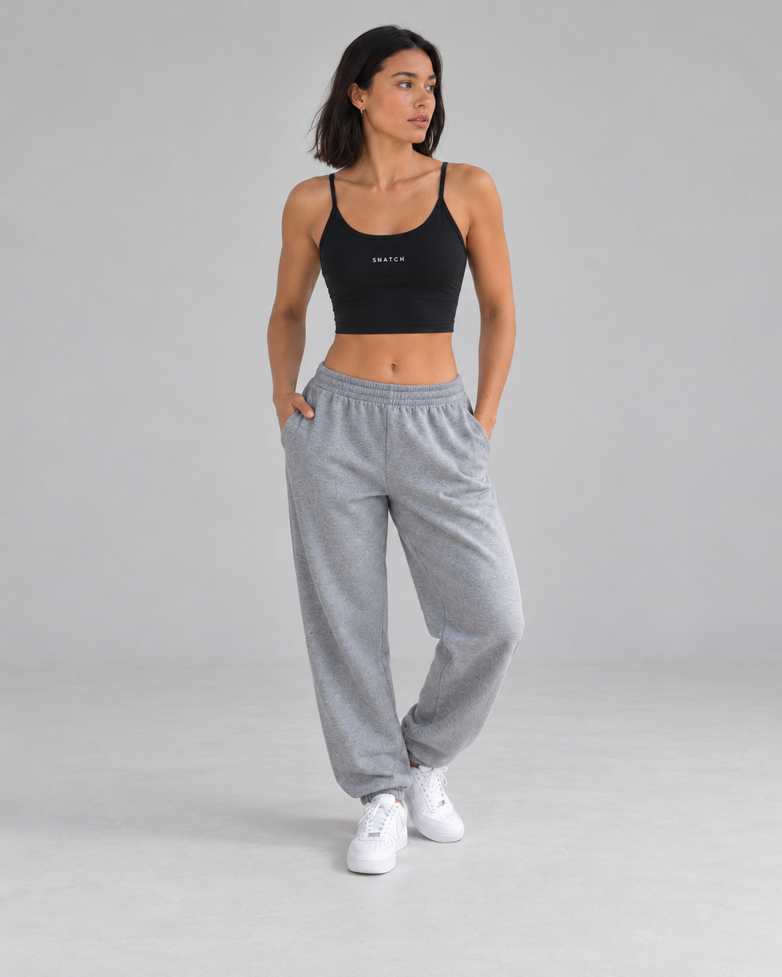 Crop top Active Snatch noir, silhouette entière en studio gris — visuel généré
