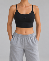 Crop top Active Snatch noir porté de face en studio gris — visuel généré
